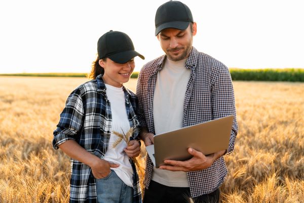 Couple of farmers examines the field of cereals